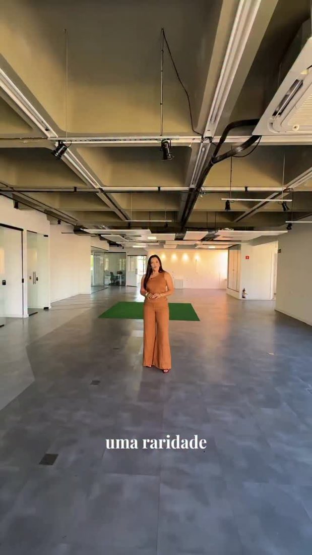 Designer de macacão laranja no salão vazio de um showroom, vídeo para Ana Paula Lima Interiores