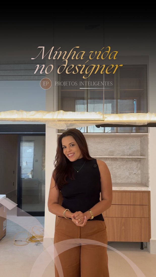 Designer sorrindo num living com cristaleira iluminada, vídeo da Ana Paula Lima Interiores